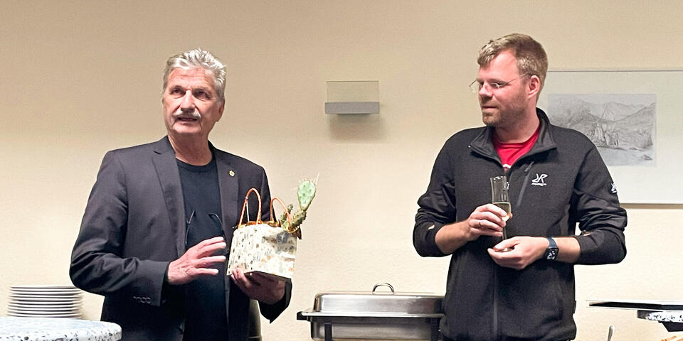 Ein Mann überreicht einem anderen Mann ein Geschenk