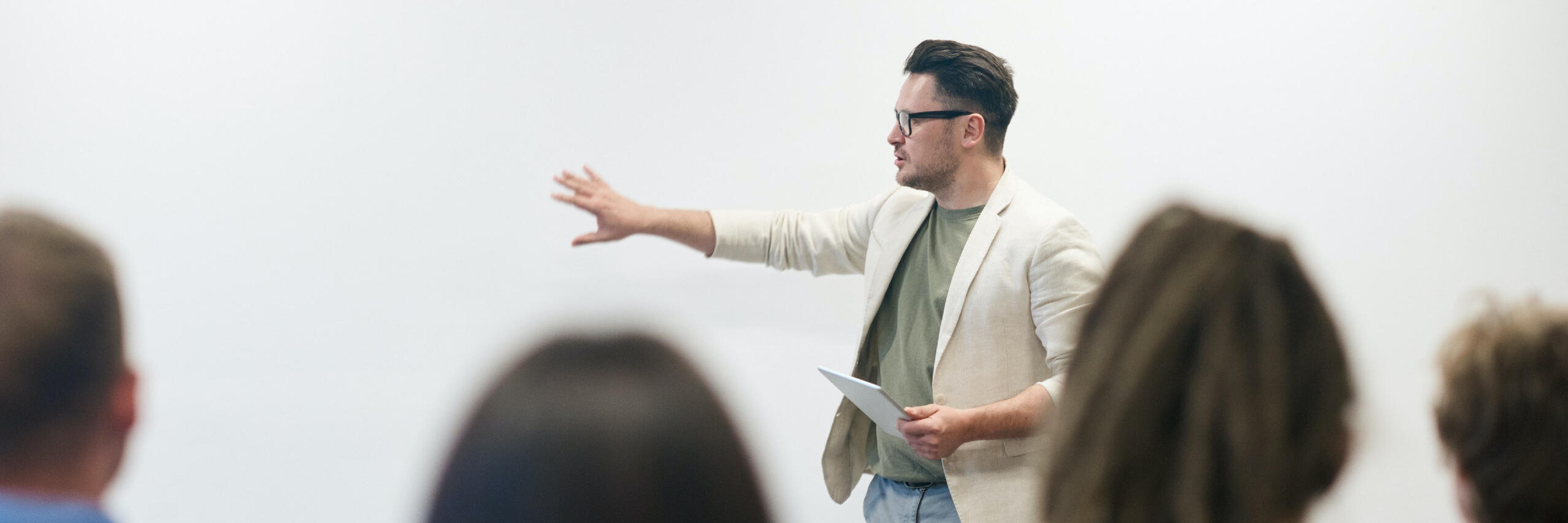 Ein Mann in beigem Blazer unterrichtet.