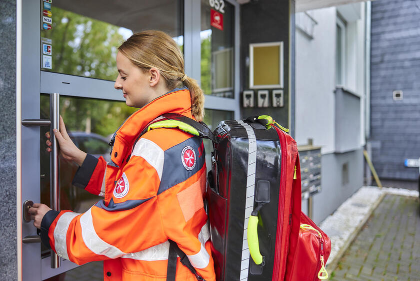 Einsatzdienstmitarbeiterin öffnet Türe