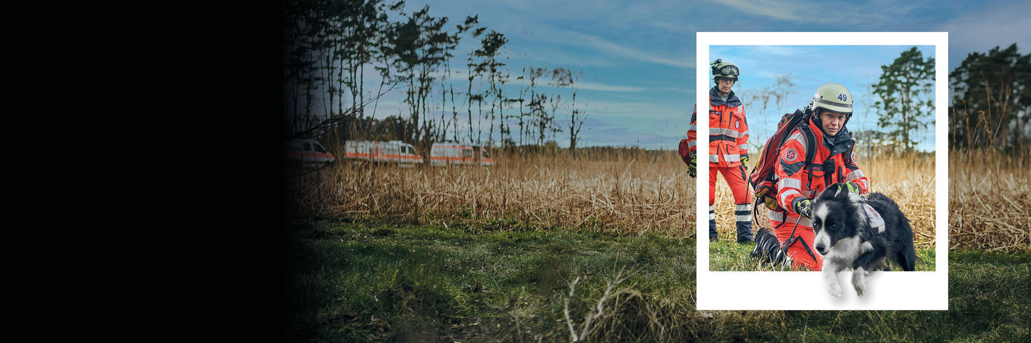 Ehrenamtliche Mitglieder einer Rettungshundestaffel in Einsatzkleidung auf freier Fläche