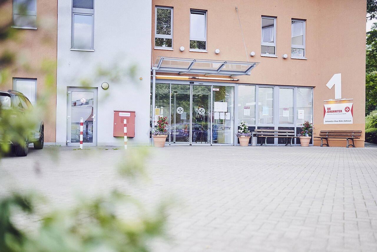 Vorplatz mit Gartenbank und Sicht zum Eingang des Johanniter-Hauses Köln Zollstock.