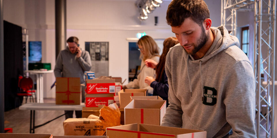 Menschen packen Weihnachtstrucker-Pakete
