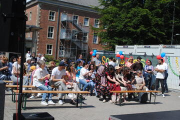 Menschen feiern vor der Landesunterkunft bei Livemusik.