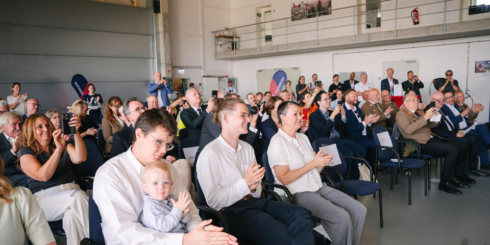 Die Gäste beim Festakt beklatschen eine der Reden.