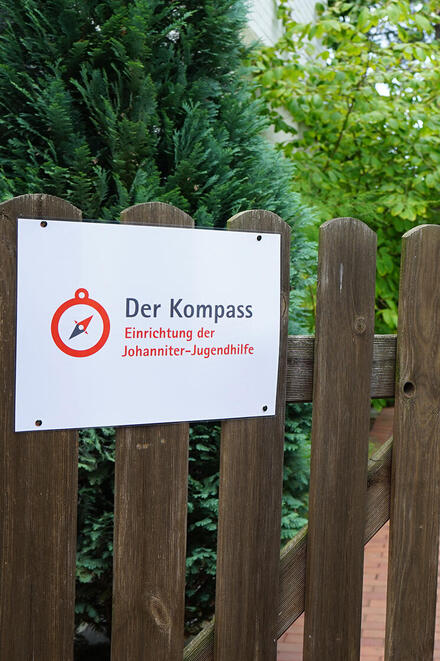Hölzerne Gartentür mit Schild "Johanniter-Jugendhilfe"