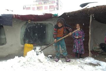 Kinder befreien regelmäßig die Dächer von Schnee. Andernfalls dringt Tauwasser in den Innenraum der Hütten ein. 