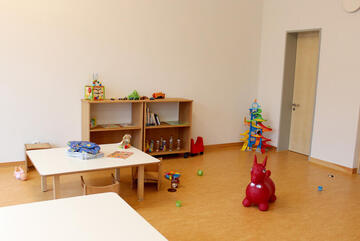 Blick in den Gruppenraum der Koalas, man sieht zwei kleine Tische und zahlreiche Spielsachen.