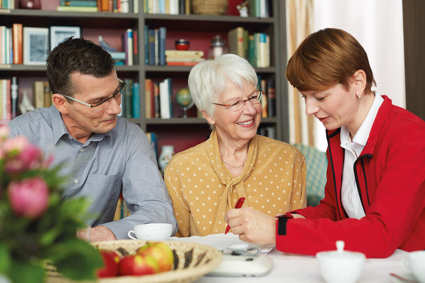 Eine Frau berät einen Mann und eine ältere Dame