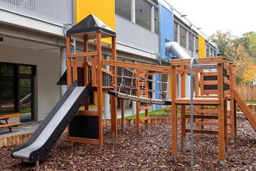 Nahaufnahme der Rutsche und des Klettergerüsts auf der Außenanlage der Kita Lumi Natura.