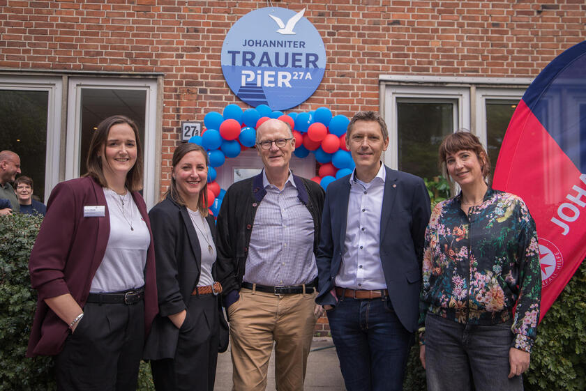 Eine Personengruppe steht vor dem Eingang des TrauerPiers 27a