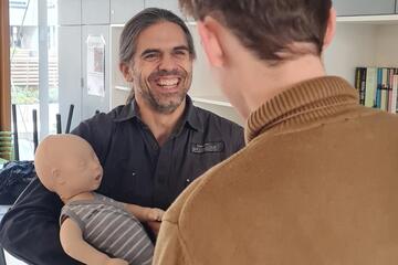 Kursteilnehmer und Kursleiter im Erste-Hilfe am Kind Kurs