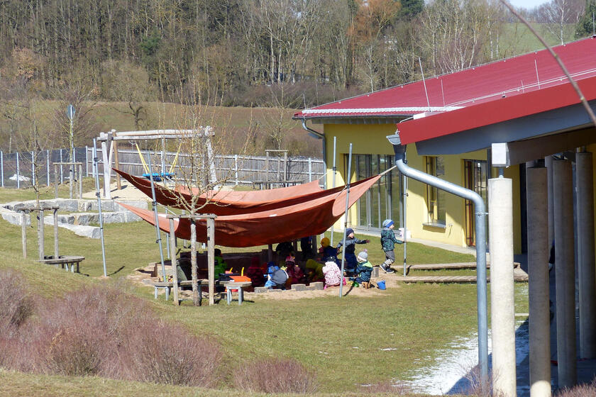 Außenansicht der Johanniter-Kinderinsel in Reckendorf mit im Garten spielenden Kindern.