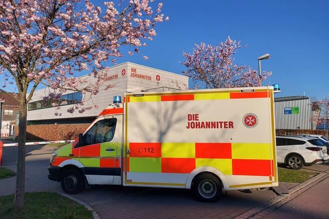 Ein RTW steht vor einer Schranke.  Im Hintergrund sieht man die Memminger Johanniter-Rettungswache.