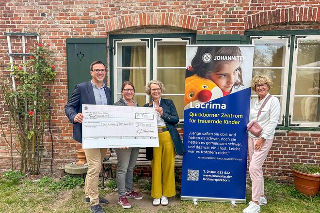 Spende für Lacrima Mitarbeitende der Johanniter sowie der Johanniter-Hilfsgemeinschaften halten einen Spendenscheck in der Hand.