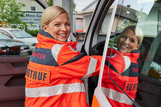 Eine frau in Johanniter-Bekleidung an einem Fahrzeug