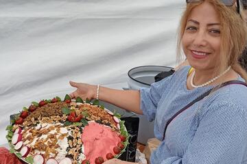 Eine Bewohnerin zeigt ein kompliziert aussehendes Gericht