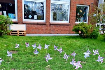 viele Windräder stecken im Rasen und bilden den Windpark.