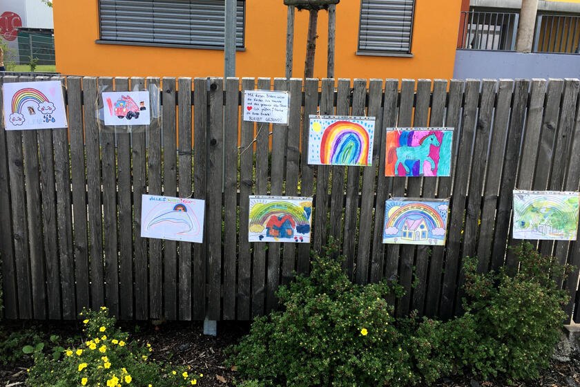 Gemalte Grüße an die Freunde und das Kita-Team zieren den Zaun vor der Kinderinsel.