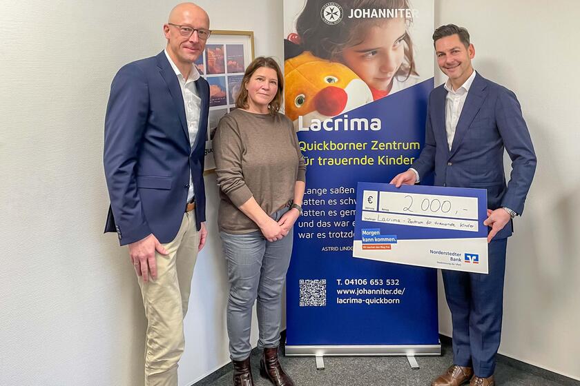 Jens-Hartwig Göttsch (l.) und André Moheit (r.) von der Volksbank Raiffeisenbank Norderstedt überreichen einen Spendenscheck in Höhe von 2.000 Euro an Evelyn Werner von den Johannitern.
