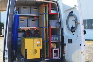 Das geöffnete Heck eines Transporters mit verschiedenen Hilfsmitteln und Rationen sowie einem Stromgenerator.