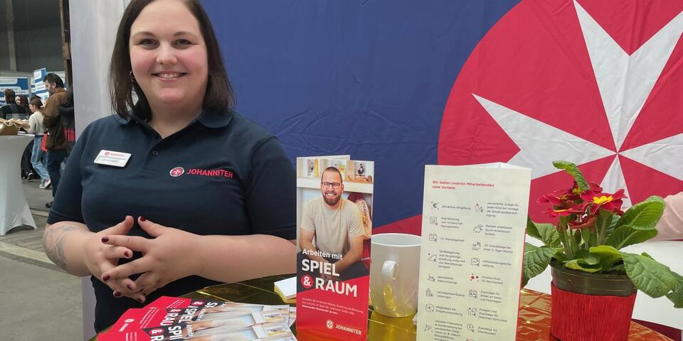 Eine Johanniterin an einem Messestand