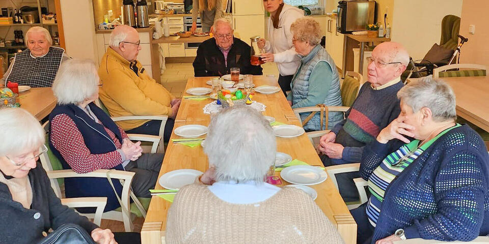 Menschen an einem österlich gedeckten Tisch