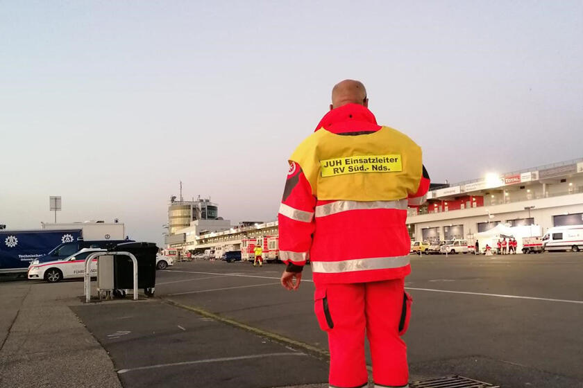 Regionalbereitschaftsführer Marc Küchemann mit Blick auf den Nürburgring und die dortigen Einsatzfahrzeuge sowie Helferinnen und Helfer.