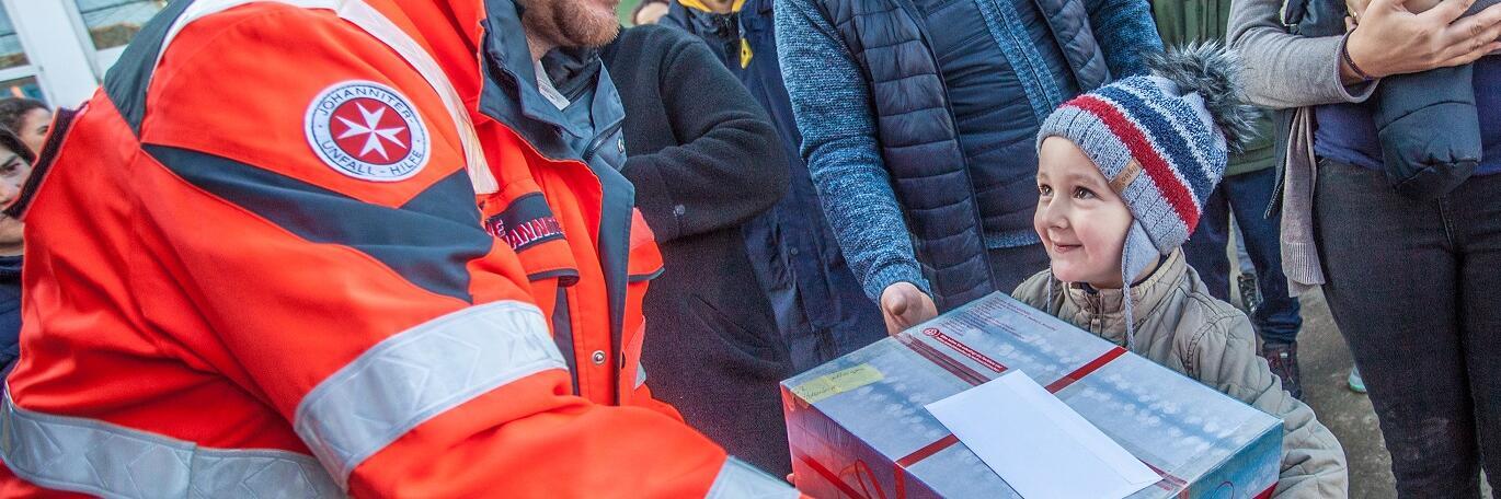 Kleiner Junge freut sich über sein Paket.