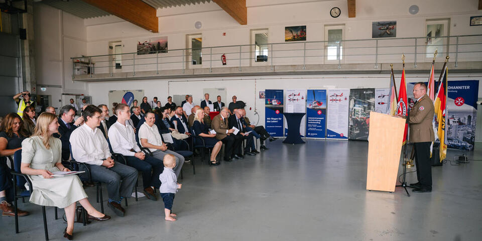 Professor Little schaut bei seiner Rede auf seinen kleinen Enkel, der nach vorne getreten ist.