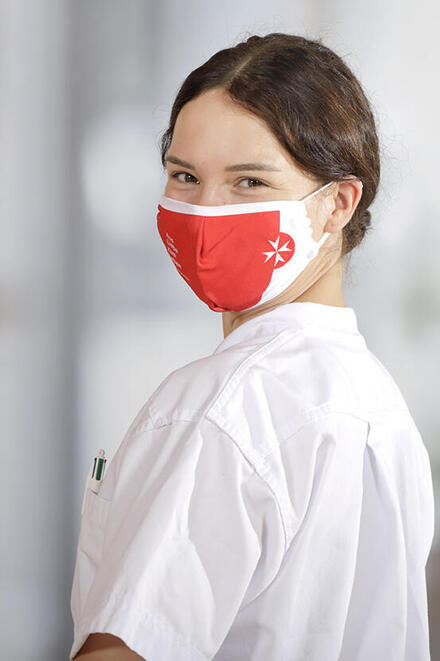 Eine Johanniter-Mitarbeiterin mit einer Corona-Schutzmaske.