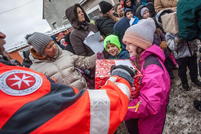 Kind erhält Weihnachtstrucker-Paket.