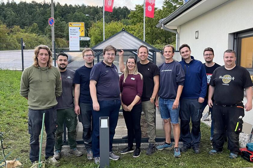 Vereinsmitglieder präsentieren stolz ihr neu errichtetes Gewächshaus