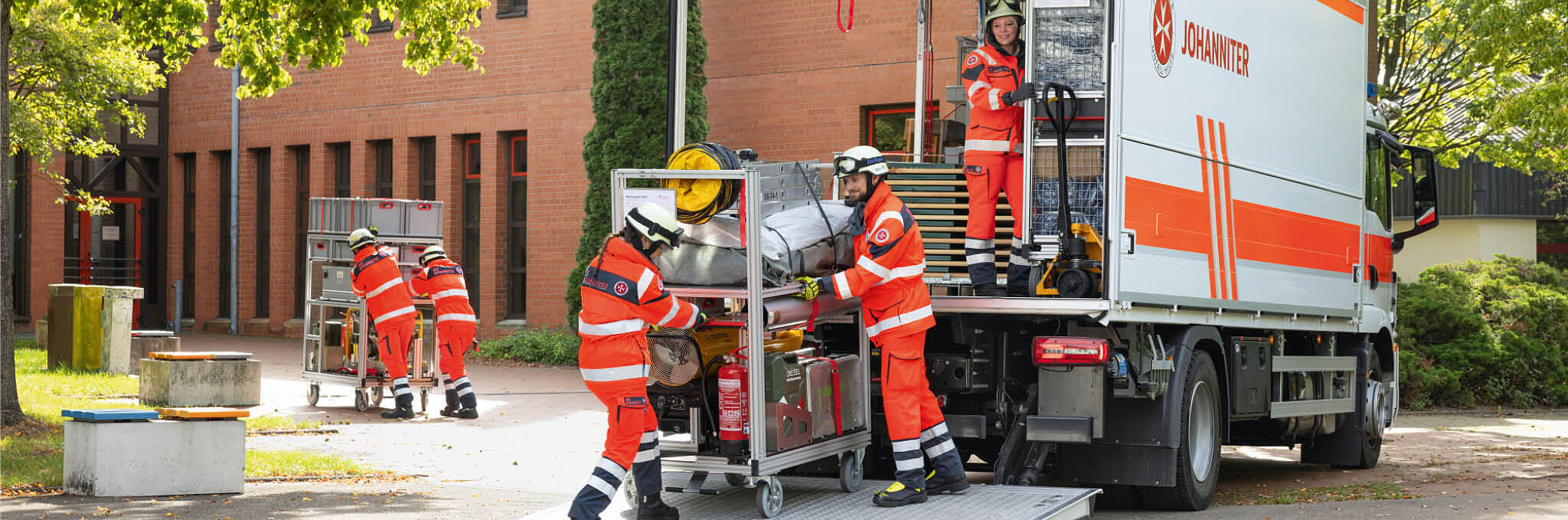 Mehrere Einsatzkräfte beladen einen Johanniter-LKW