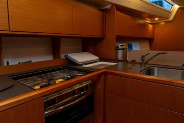 Kochbereich des Segelbootes mit Gasherd, Spüle und Kühlschrank.
