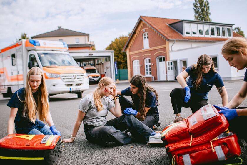 Jugendlich kümmern sich um eine verletzte Person