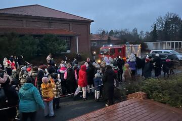 Viele Menschen begrüßen den Nikolaus im Feuerwehrfahrzeug