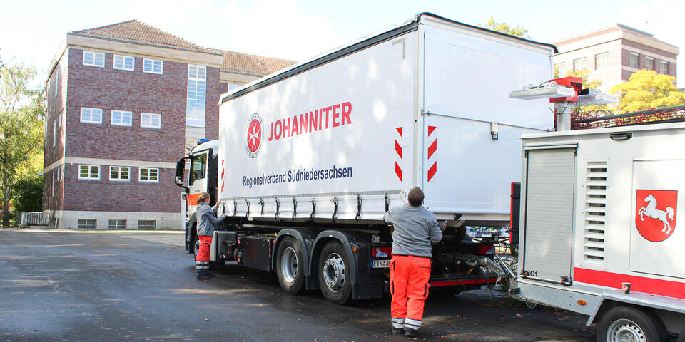 Ein Johanniter-LKW vor einer Schule