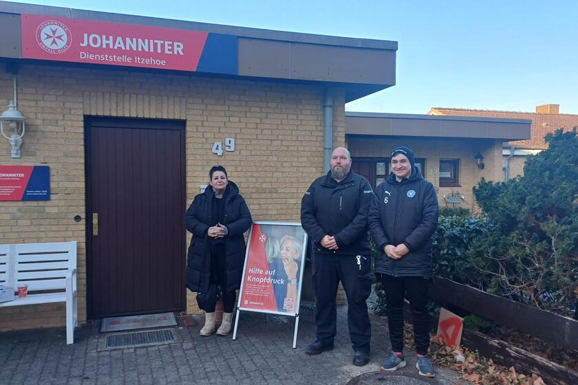 Drei Leute aus dem Einsatzdienst vor der Johanniter Dienststelle in Itzehoe