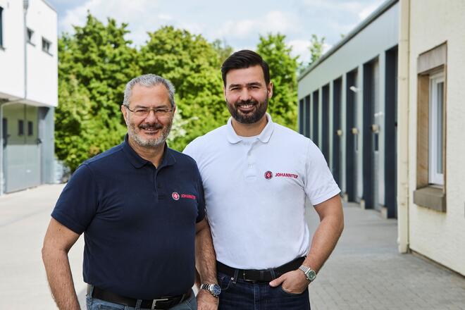 Ein älterer und ein jüngerer Mann mit Johanniter-Polo-Shirts