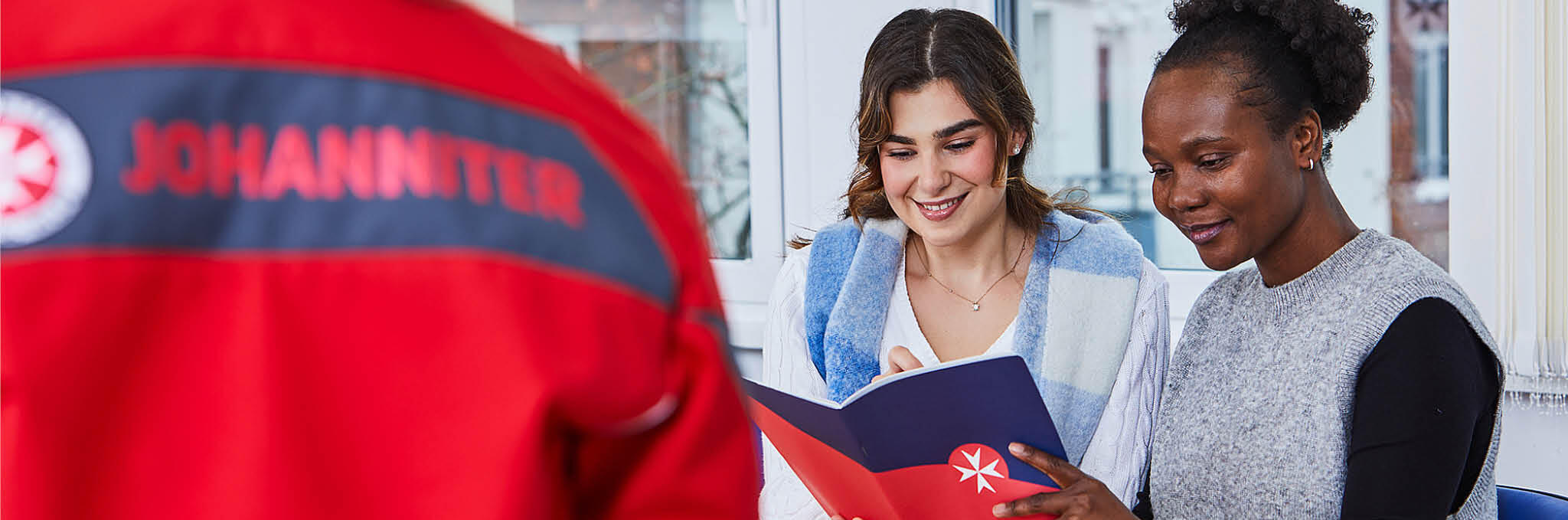 Teilnehmende an einem Lehrgang der Johanniter-Akademie in Hannover lesen in einem Heft.