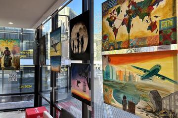 Verschiedene Kunstwerke hängen an den großen Glasfenstern des Pavillons.
