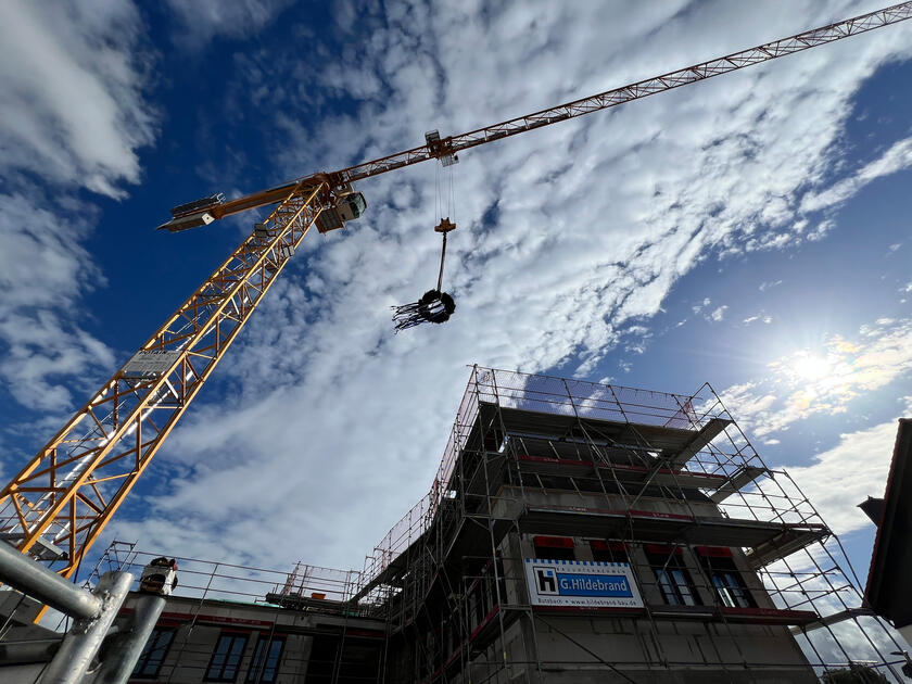 Neubau mit Richtkranz im Wind.