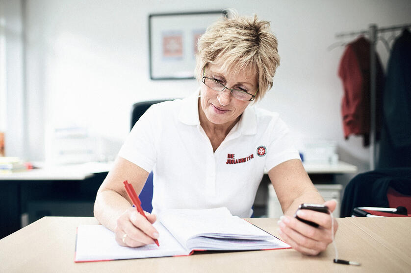 Eine Johanniter-Mitarbeiterin bei der Arbeit im Büro.