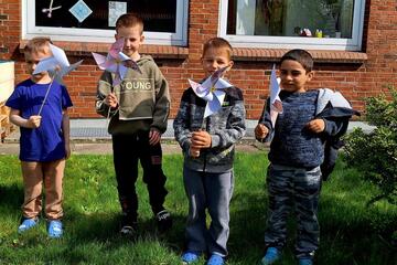Vier Jungen zeigen ihre Windräder