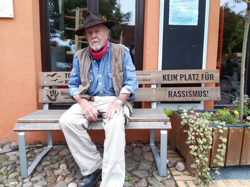 Der Künstler Gunter Demnig auf der „Bank gegen Rassismus“ vor dem Storkower Familienzentrum, 05.10.2023, Foto: T. Ulrich