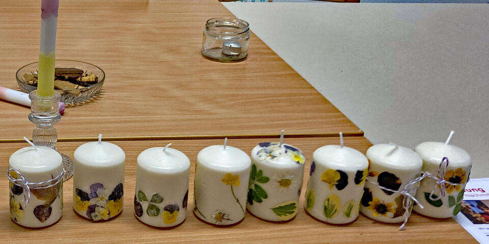 Mit Trockenblumen verschönerte Kerzen