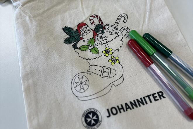 Baumwollsäckchen mit einem Nikolausstiefel bedruckt darauf liegen Filzstifte