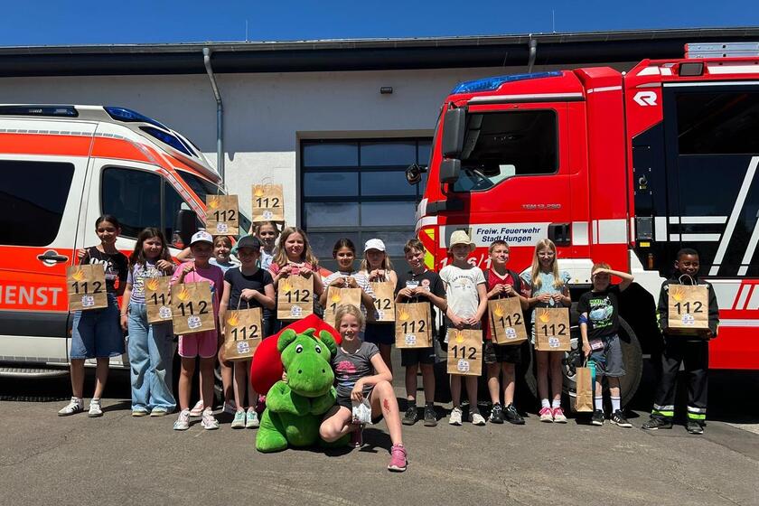 Gruppenfoto Projektgruppenschüler vor Feuerwehrfahrzeug und Rettungswagen