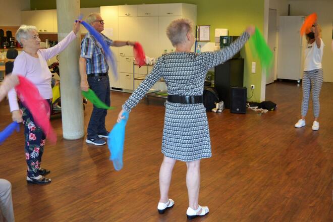 Senioren schwingen bunte Tücher und tanzen