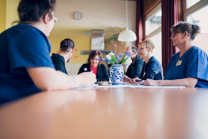 Mitarbeitende des Johanniterhaus Dannenberg sitzen an einem Tisch bei einer Besprechung